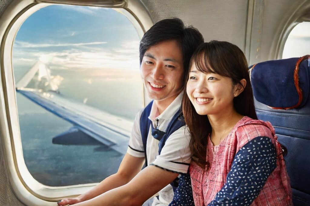 飛行機に乗っている日本人カップル